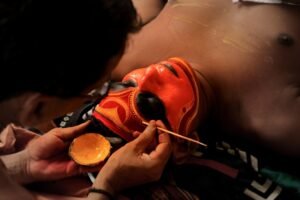 Applying orange paint to a red mask