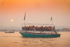 Boat full of people on a calm river at sunset